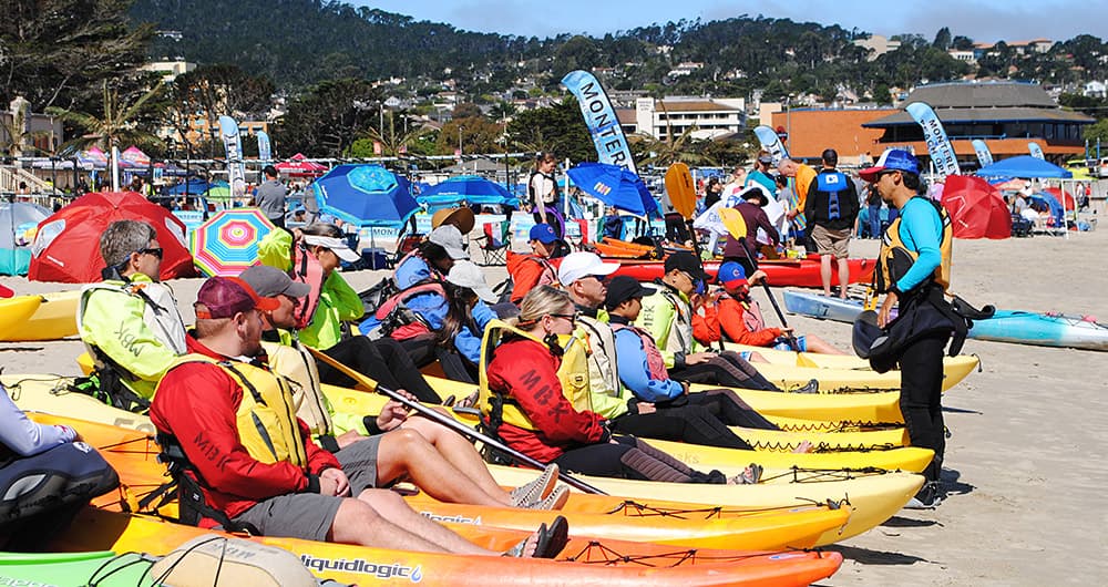 people sitting in kayak on the beach recieving instructions