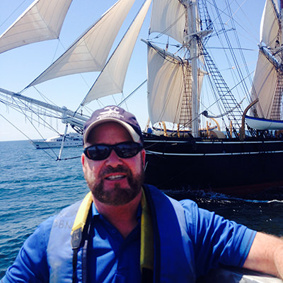 man standing in front of a tall ship