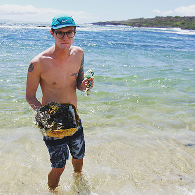 a person holding a bucket full of marine debris