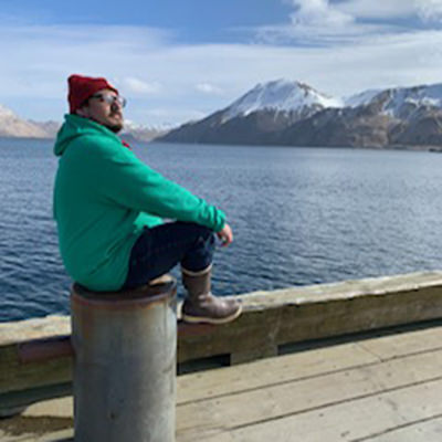 a man sitting on a pier in front of the ocean