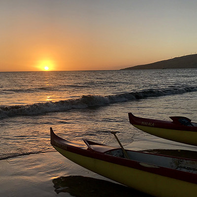outrigger canoes at sunset