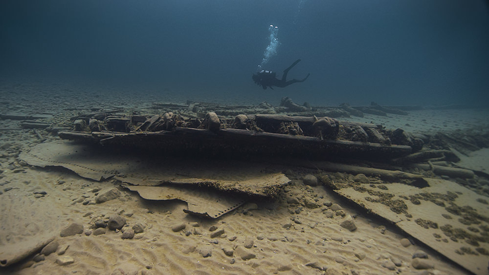 diver swimming past a shipwreck