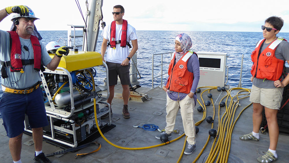 ROV operators Lance Horn (left) and Eric Glidden (rear) brief Nadia Alomari and Marissa Nuttall (NOAA) on collection procedures for the black coral