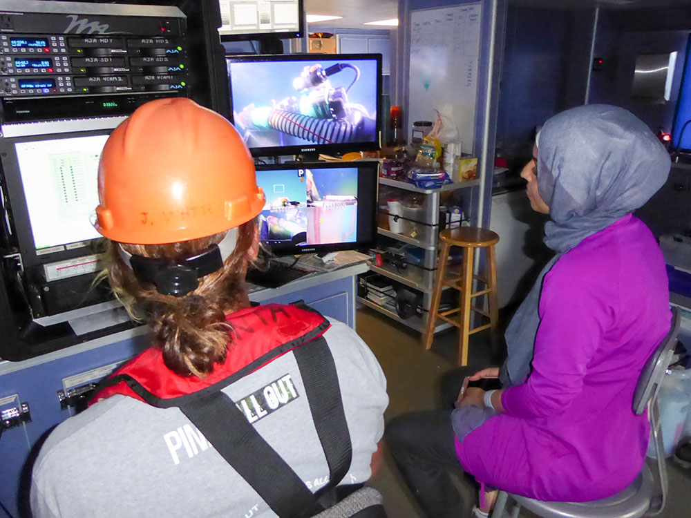 Jason White and Nadia Alomari observe ROV footage aboard the R/V Manta