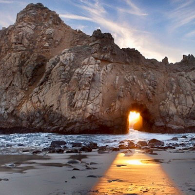 Light streaming through an arch on the beach