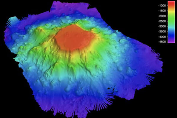 A bathymetric color map of a seamount showing the base of the seamount as cooler colors representing deeper water depth, and the summit of the seamount in red indicating shallower water depth.
