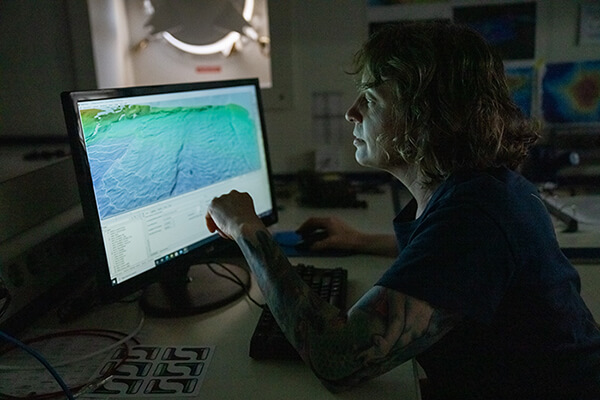 A person at a computer looking at mapping data