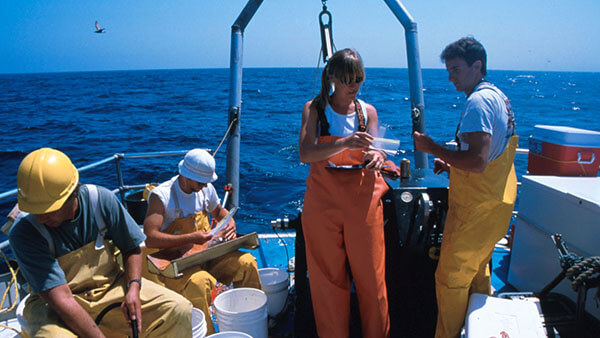 people on a research vessel observe samples