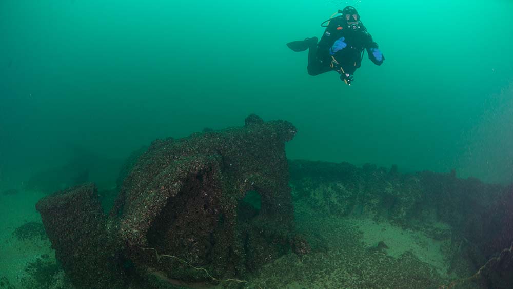 a scuba diver swims over a shipwreck