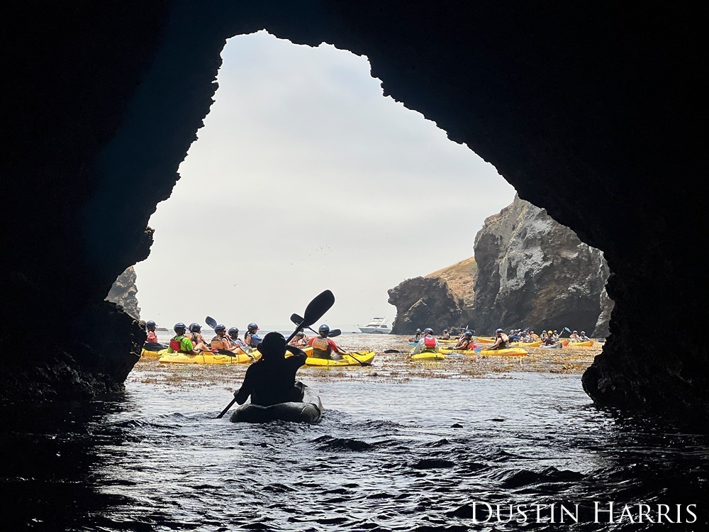 From inside of the cave, a large group of kayakers paddling near by.