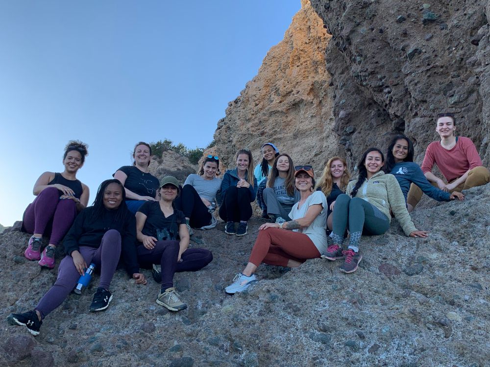 Group photo of the scholars sitting on rocks during the 2022 Nancy Foster Scholar Retreat.