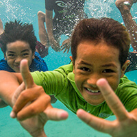 ChildreChildren swim in the tropical waters of National Marine Sanctuary of American Samoa